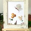 A lovely scene with a butterfly, snail, and flowers, made with seaglass and seashells, perfect as a unique gift!