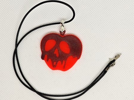 glow in the dark red apple with melting black holographic skull pendant
