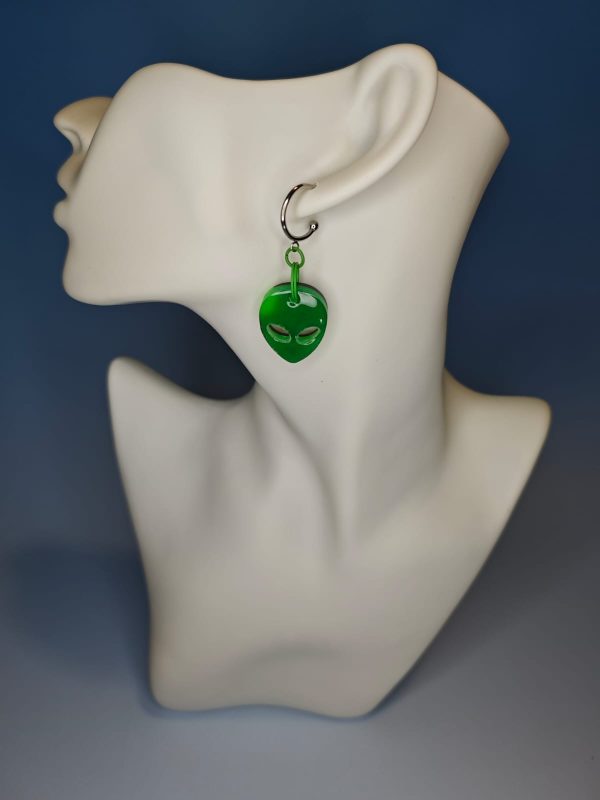 green alien earrings on a mannequin