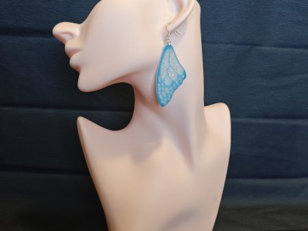 Blue butterfly wing earrings on a mannequin