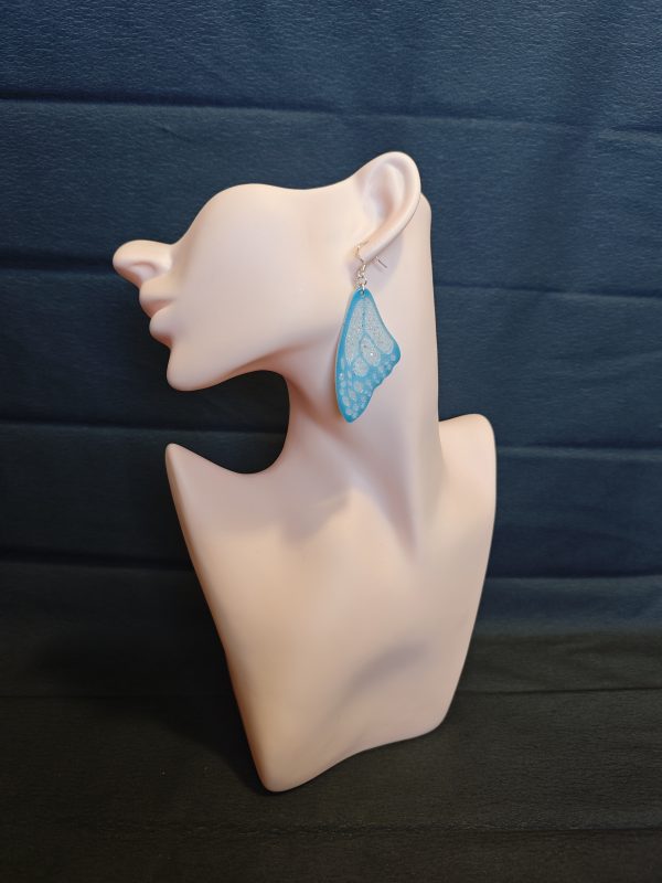 Blue butterfly wing earrings on a mannequin